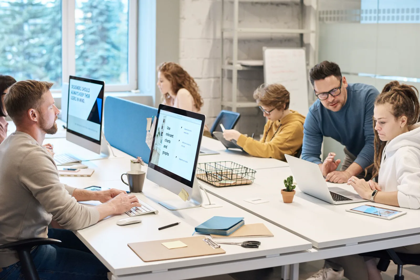 Equipe reunida em planejamento com computadores e documentos